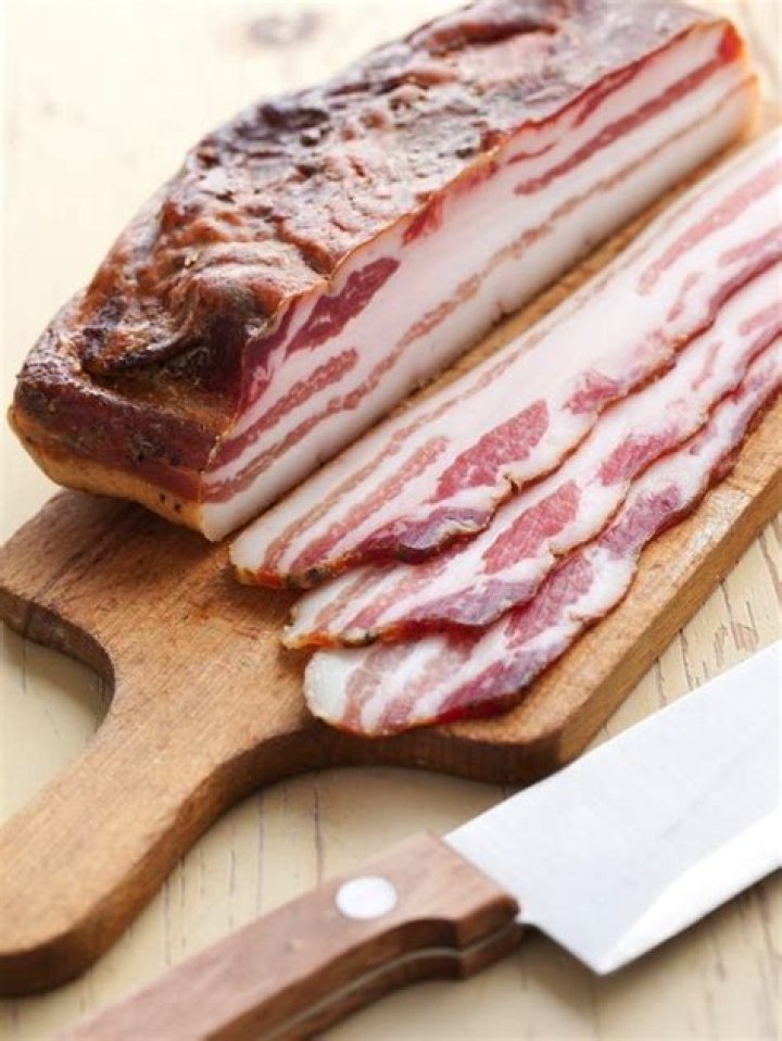 How do you keep bacon from curling when cooking?