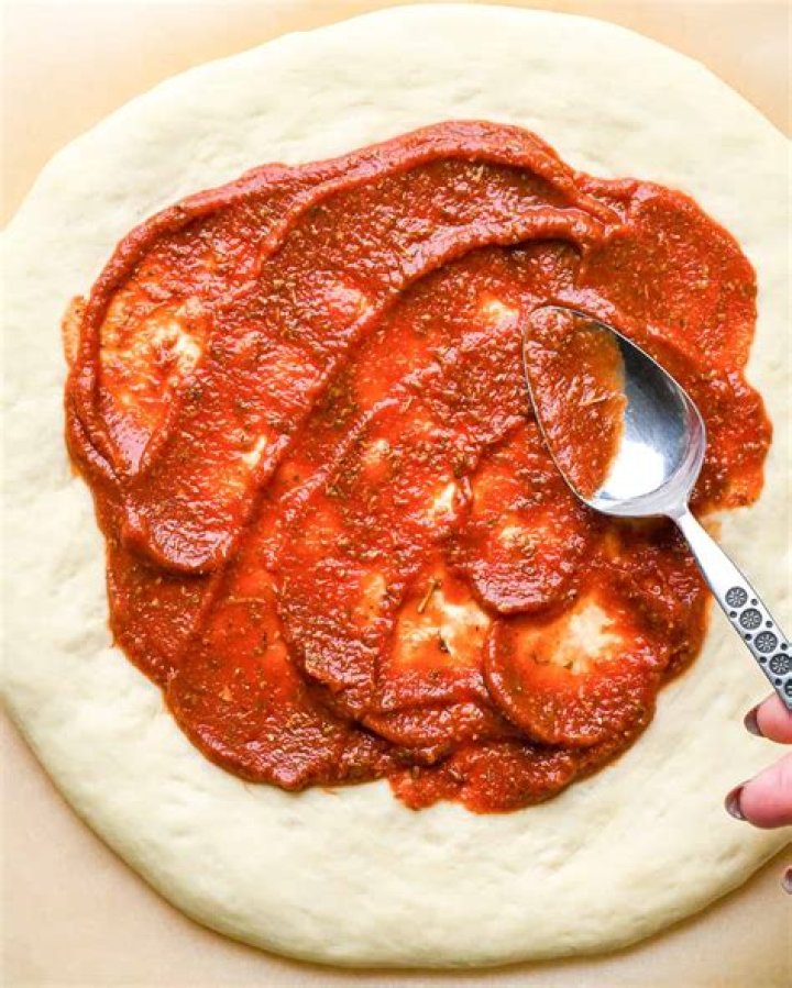 How do you put pizza sauce on pizza?