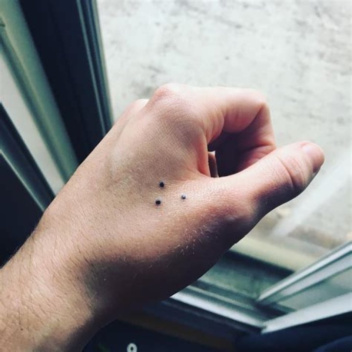 What does it mean when someone has dots tattooed on their fingers?